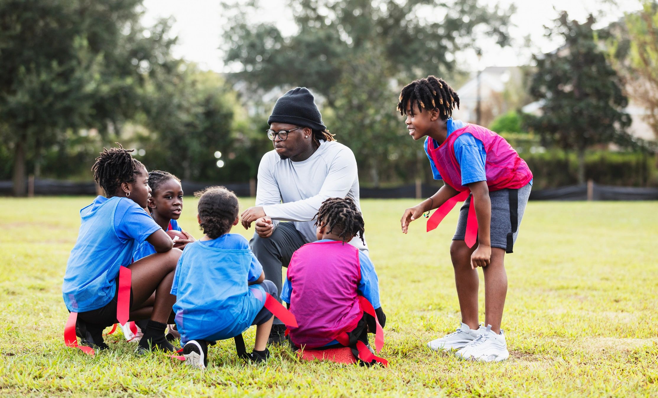 Coach speaking with youth athletes in a huddle
